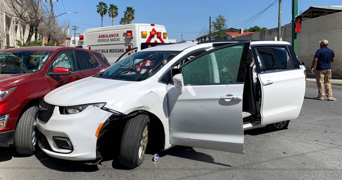 Un miembro de las fuerzas de seguridad de México permanece cerca del monovolumen blanco con placas de Carolina del Norte y con varios agujeros de bala, en el lugar en el que hombres armados secuestraron a cuatro ciudadanos de Estados Unidos que cruzaron a México desde Texas el viernes 3 de marzo de 2023.