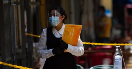 Una mesera espera la llegada de clientes a un restaurante en el Centro Histórico.