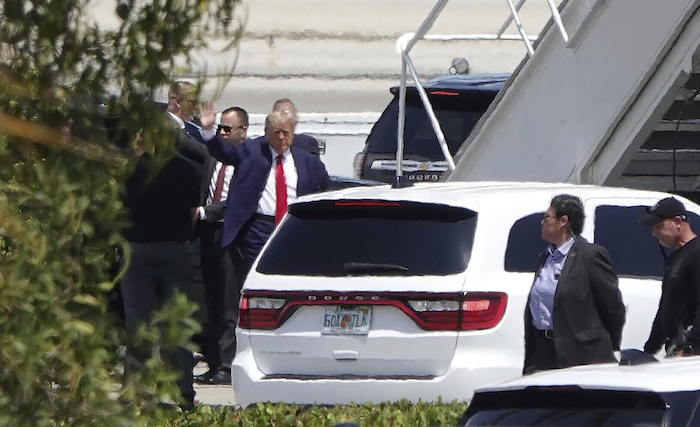 El expresidente Donald Trump saluda antes de abordar su avión el lunes 3 de abril de 2023 en el Aeropuerto Internacional de Palm Beach, en West Palm Beach, Florida. 