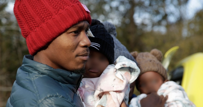 El migrante haitiano Gerson Solay, con su hija Bianca en brazos, y su familia entran a Canadá por el cruce no oficial de Roxham Road al norte de Champlain, Nueva York, viernes 24 de marzo de 2023.