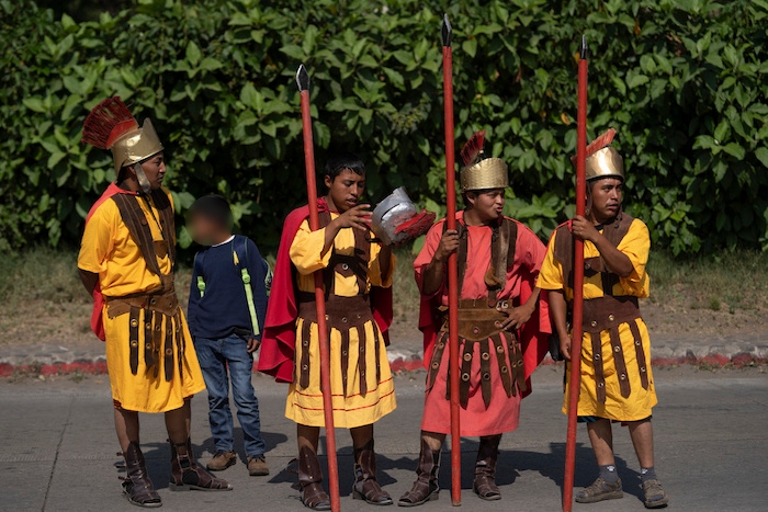 Fieles disfrazados de soldados romanos participan en una procesión afuera de la iglesia católica San Cristóbal el Bajo en Antigua, Guatemala, el jueves 6 de abril de 2023.