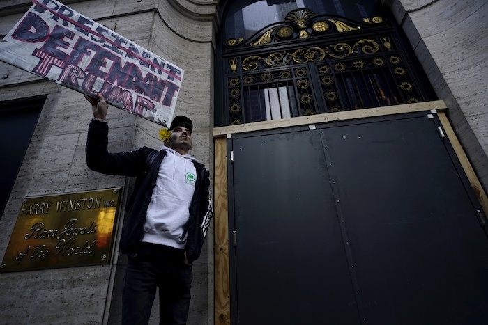 Lucas Camp, de Astoria, sostiene un cartel junto a la Trump Tower el martes 4 de abril de 2023 en Nueva York. El expresidente Donald Trump sería procesado el martes para enfrentar cargos penales derivados de pagos para silenciar a mujeres durante su campaña en 2016.