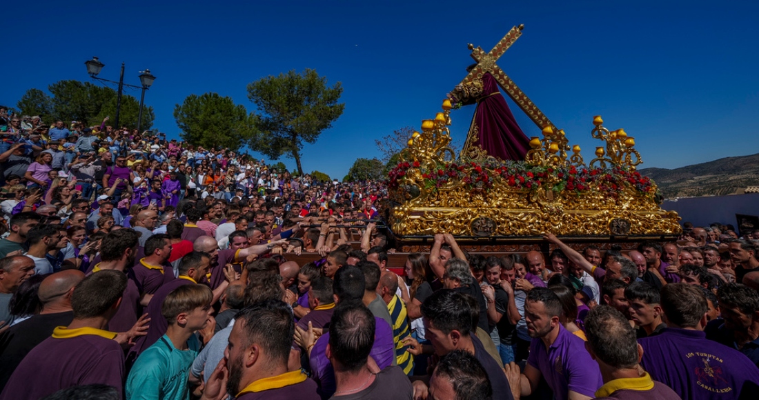 Penitentes de la hermandad de "Padre Jesús Nazareno" cargan un dosel con una estatua de Jesucristo con su cruz durante una procesión de Samana Santa en Priego de Córdoba, en el sur de España, el viernes 7 de abril de 2023.