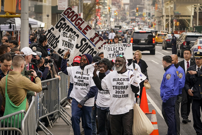 Simpatizantes del expresidente Donald Trump desfilan con sus carteles frente a los medios de comunicación y los curiosos reunidos frente al Tribunal Penal de Manhattan, el martes 4 de abril de 2023, en Nueva York.