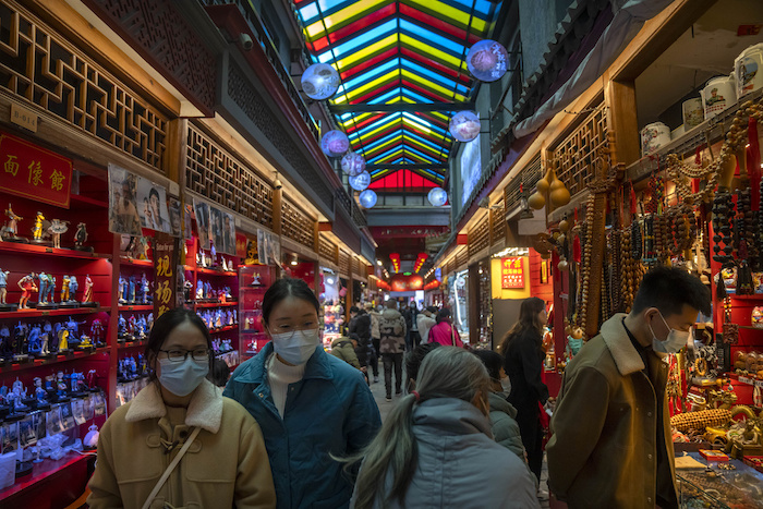 Visitantes recorren tiendas que venden recuerdos en una calle de comercios turísticos, el 28 de febrero de 2023, en Beijing.