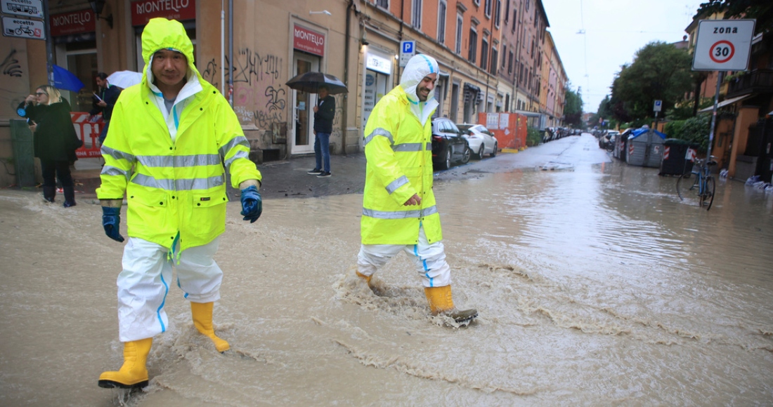 Dos personas cruzan una calle anegada en Bolonia, Italia, el 16 de mayo de 2023.