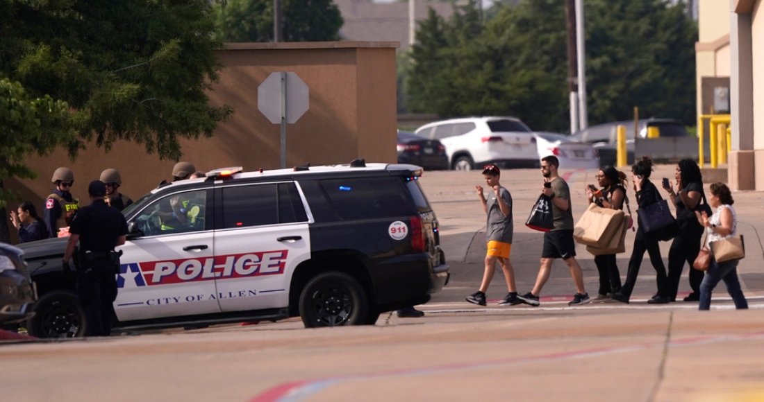 Gente con las manos en alto a la salida de un centro comercial tras reportes de un tiroteo el sábado 6 de mayo de 2023 en Allen, Texas.