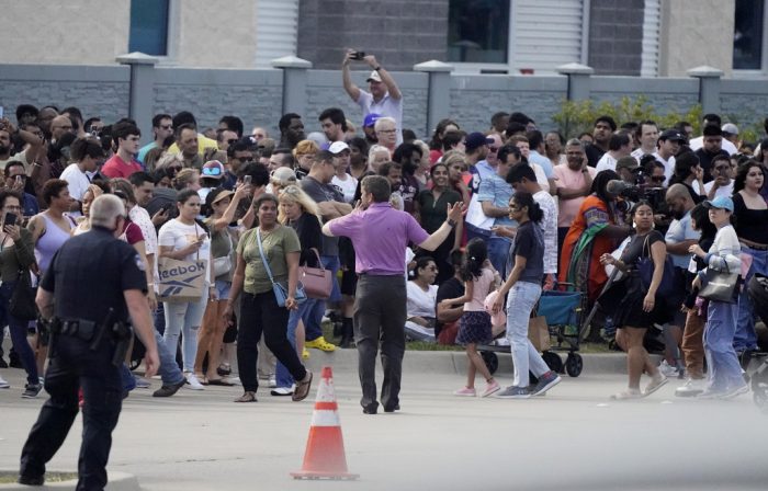 Personas se reúnen del otro lado de la calle de un centro comercial tras un tiroteo el sábado 6 de mayo de 2023 en Allen, Texas.