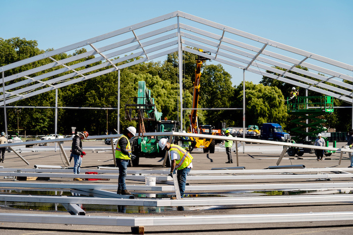 Trabajadores levantan una carpa en el estacionamiento de Orchard Beach, en el barrio del Bronx, en Nueva York, el 27 de septiembre de 2022, con el fin de usarla como albergue temporal para miles de migrantes extranjeros que han sido enviados a la ciudad.