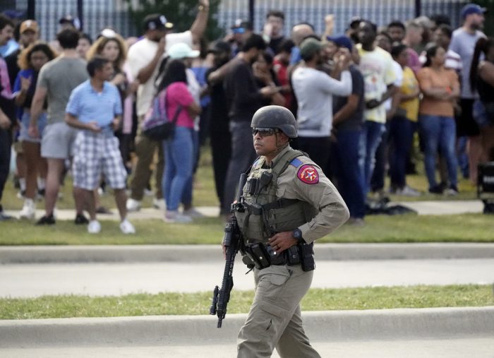 Un agente policial vigila durante el desalojo de clientes y personal de un centro comercial en que se registró un tiroteo, el sábado 6 de mayo de 2023, en Allen, Texas.