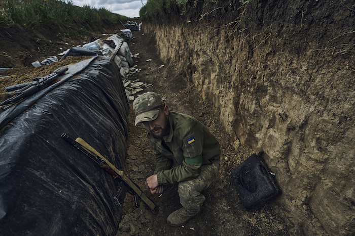 Un soldado ucraniano se sienta en una trinchera en el frente cerca de Bájmut, en la región de Donetsk, Ucrania, el lunes 22 de mayo de 2023.