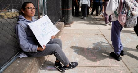 Una manifestante fuera de la escuela pública 172 mientras los estudiantes salen de clases, el martes 16 de mayo de 2023, en Nueva York.