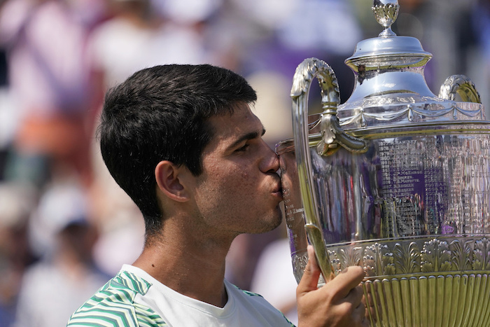 Carlos Alcaraz besa el trofeo tras derrotar a Alex de Miñaur en la final del torneo del Queen's Club, el domingo 25 de junio de 2023, en Londres.