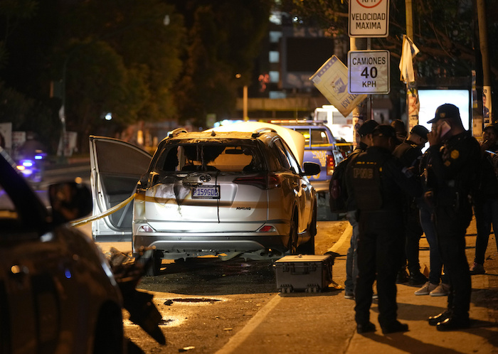 La policía acordona una zona donde un vehículo fue incendiado con un cóctel molotov cerca de un centro de votación, después de las elecciones general en Ciudad de Guatemala, el domingo 25 de junio de 2023.