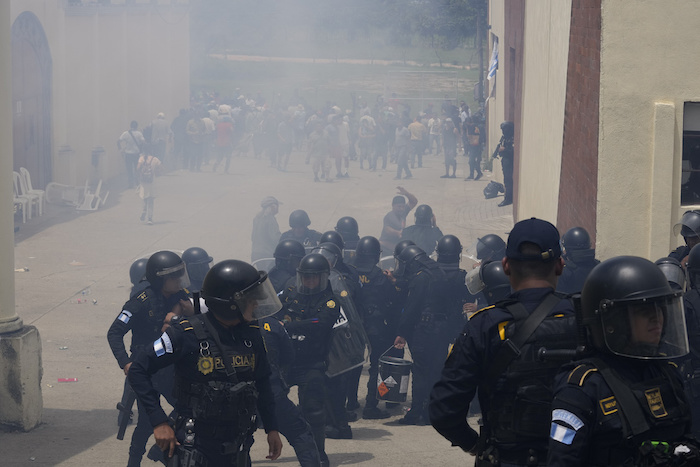 La policía lanza gases lacrimógenos en un centro de votación luego de que estallaron enfrentamientos cuando las autoridades electorales retrasaron la apertura debido a presuntas violaciones electorales durante los comicios generales en San José El Golfo, en las afueras de Ciudad de Guatemala, el domingo 25 de junio de 2023.