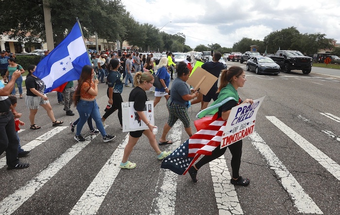 Manifestantes cruzan una calle, el jueves 1 de junio de 2023, en Orlando, Florida, durante una protesta contra la nueva ley de migración de Florida que promulgó el Gobernador Ron DeSantis.