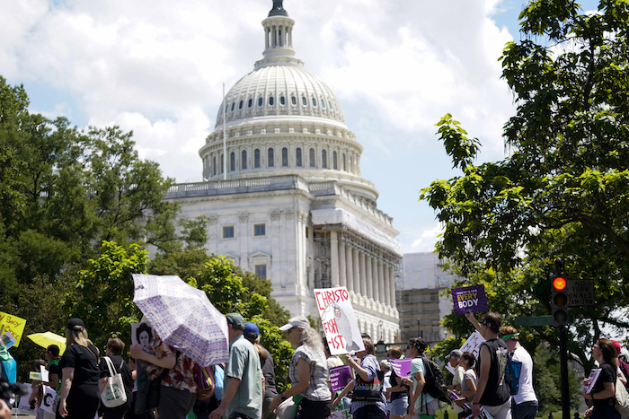 Manifestantes sostienen carteles en su marcha por el Capitolio de Estados Unidos durante la Marcha de las Mujeres en Washington, el sábado 24 de junio de 2023.