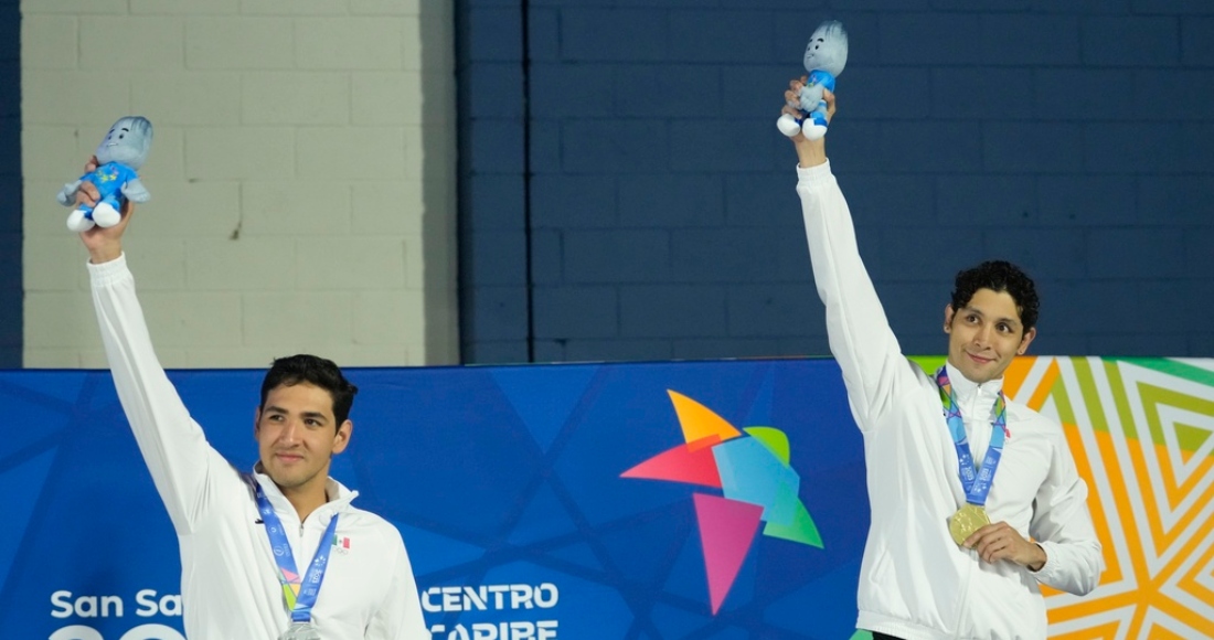 Miguel de Lara (derecha) y Andrés Puente, posan respectivamente con el oro y la plata que consiguieron para México en los 100 metros pecho de natación, el domingo 25 de junio de 2023, en los Juegos Centroamericanos y del Caribe de San Salvador.