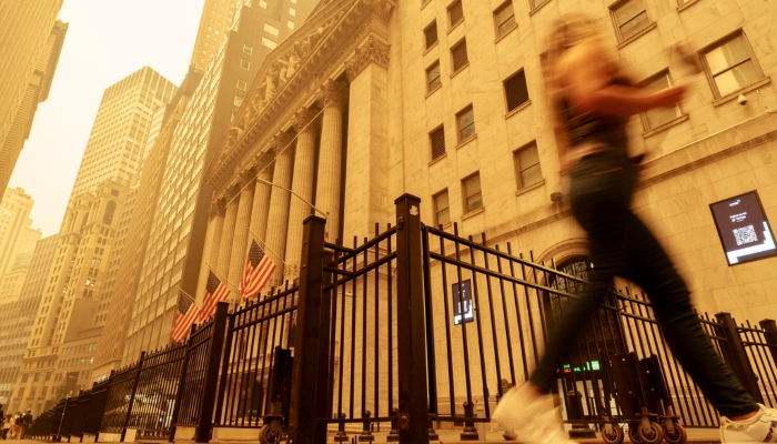 Una transeúnte camina entre el humo y la bruma cerca de la Bolsa de Valores de Nueva York, el miércoles 7 de junio de 2023. Foto: J. David Ake, AP