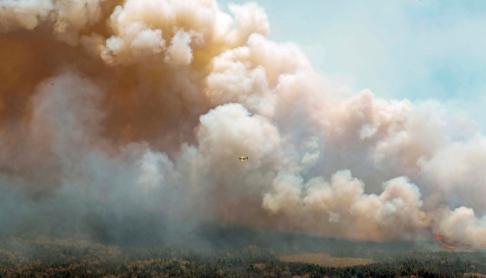 En esta imagen aérea, un avión, al centro, vuela cerca de un incendio forestal cerca del lago Barrington, condado de Shelburne, en Nueva Escocia, el miércoles 31 de mayo de 2023. Foto: Communications Nova Scotia, The Canadian Press, AP