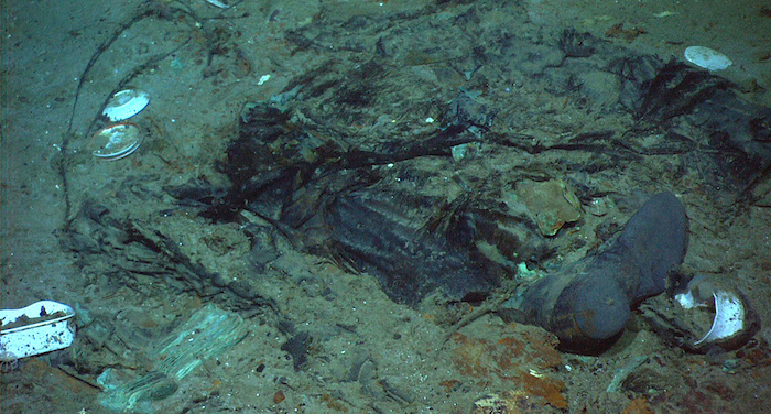 Esta fotografía de 2004 proporcionada por el Institute for Exploration, Center for Archaeological Oceanography/University of Rhode Island/NOAA Office of Ocean Exploration, muestra los restos de un abrigo y de unas botas en el fondo marino cerca del sitio donde se encuentran los restos del Titanic.