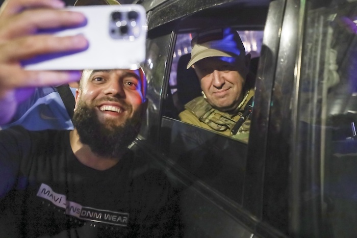 Yevgeny Prigozhin, propietario de la compañía militar Grupo Wagner, a la derecha, se sienta en un vehículo militar y posa para una selfie con un civil en una calle de Rostov en el Don, Rusia, el sábado 24 de junio de 2023 antes de abandonar una zona del cuartel general del Distrito Militar Sur de Rusia.