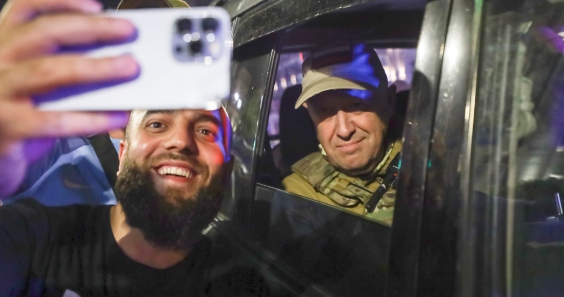 Yevgeny Prigozhin, propietario de la compañía militar Grupo Wagner, a la derecha, se sienta en un vehículo militar y posa para una selfie con un civil en una calle de Rostov en el Don, Rusia, el sábado 24 de junio de 2023 antes de abandonar una zona del cuartel general del Distrito Militar Sur de Rusia.