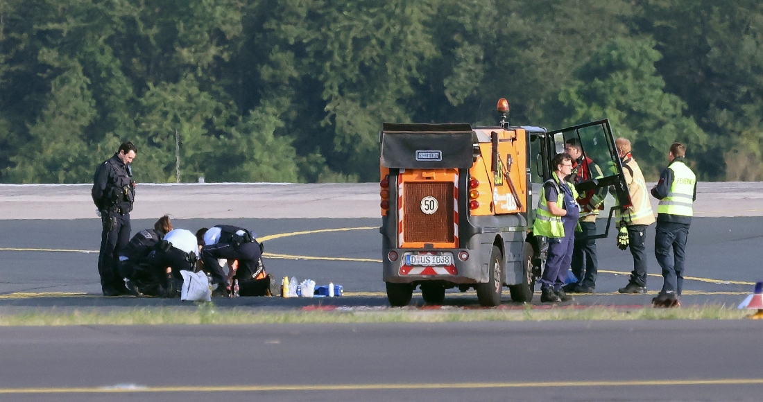 Agentes de policía y personal de seguridad se ven de pie en un aeropuerto y tratan de despegar a activistas del grupo Last Generation que se habían pegado al asfalto en la zona del aeropuerto en Düsseldorf, Alemania, el jueves 13 de julio de 2023. Foto: David Young, dpa, vía AP