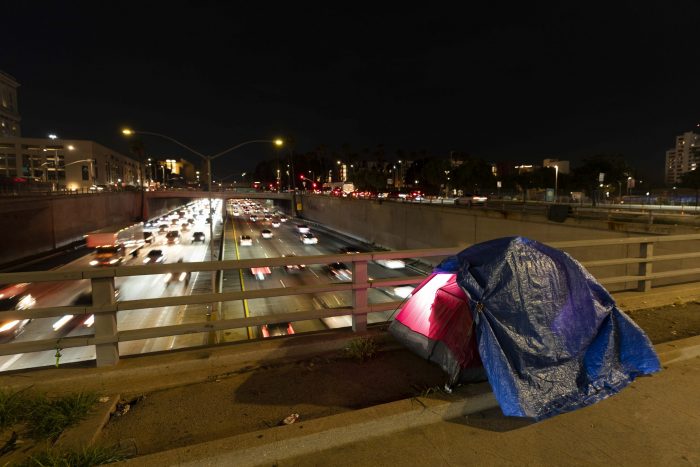 Foto de una carpa de campaña de un indigente en un puente sobre la autopista 101 en Los Ángeles, el 2 de febrero de 2023. La carpa fue iluminada mediante un flash externo.