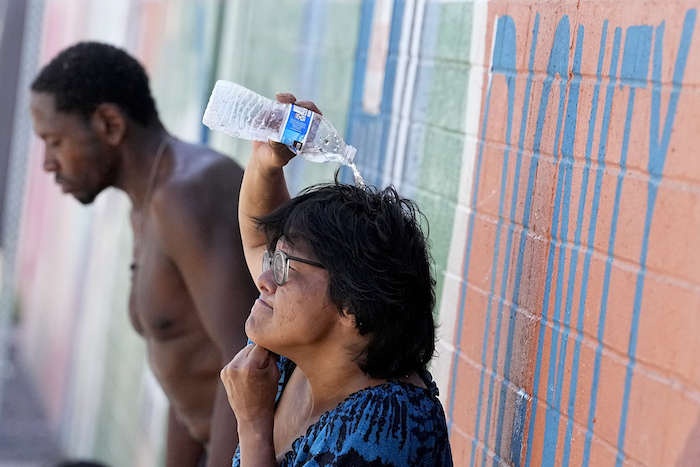 Dos personas sin hogar tratan de protegerse del calor el 14 de julio de 2023, en Phoenix.