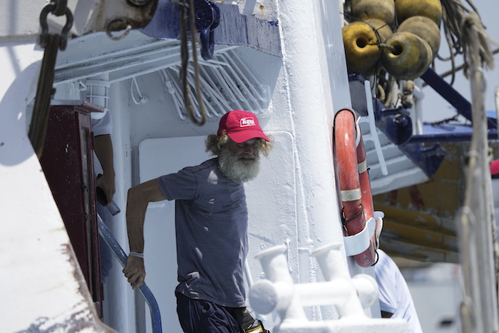 El australiano Timothy Lyndsay Shaddock baja del atunero María Delia que les rescató a él y a su perra Bella, en el puerto de Manzanillo, México, el martes 18 de julio de 2023.