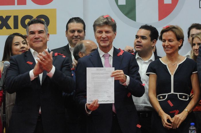 Enrique de la Madrid entrega su hoja de registro a Alejandro Moreno.