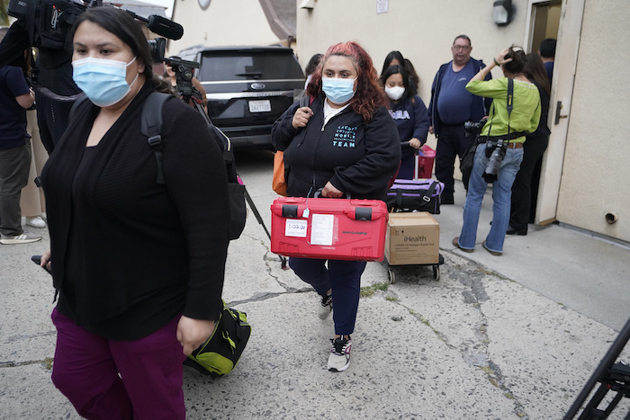 Funcionarios del servicio público de Operaciones de Emergencias del Condado Los Ángeles salen de la Iglesia católica croata de San Antonio, en Los Ángeles, tras evaluar a varios migrantes alojados en la ciudad el miércoles 14 de junio de 2023.