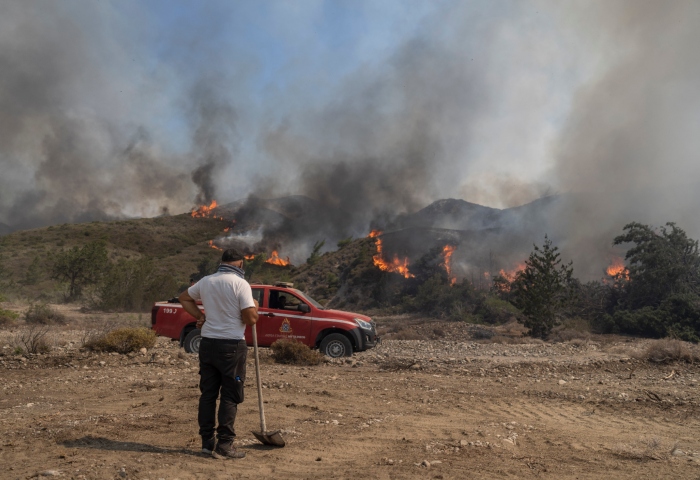 Un hombre observa las llamas que queman un monte en la localidad de Vati, en la isla de Rodas, en el sureste de Grecia, el 25 de julio de 2023. Foto: Petros Giannakouris, AP