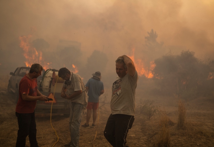 Vecinos de la zona tratan de extinguir un incendio forestal activo en la localidad de Gennadi, en la isla de Rodas, en el sureste de Grecia, el 25 de julio de 2023. Foto: Petros Giannakouris, AP