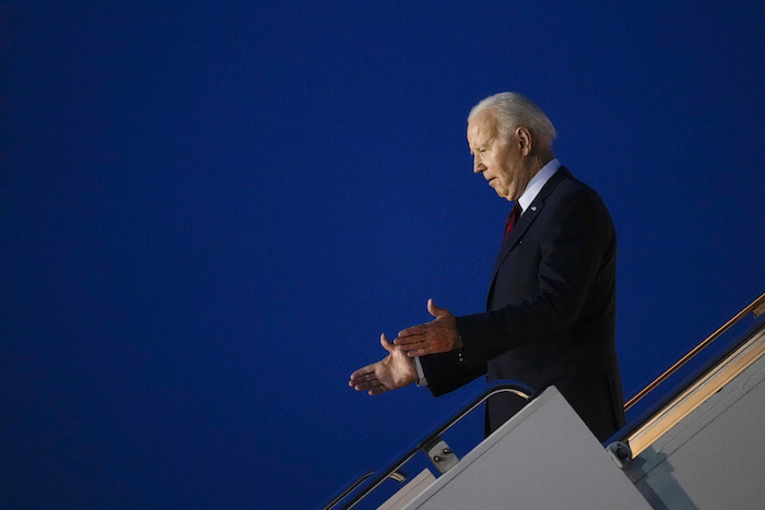 El Presidente Joe Biden realiza un gesto a las personas que lo esperan al pie de las escaleras del avión presidencial a su llegada al Aeropuerto Stansted, el domingo 9 de julio de 2023, en Stansted, Inglaterra.