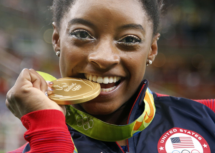 La gimnasta estadounidense Simone Biles muerde su medalla de oro tras ganar en el concurso completo de los Juegos Olímpicos de Río de Janeiro 2016, el 11 de agosto de 2016.