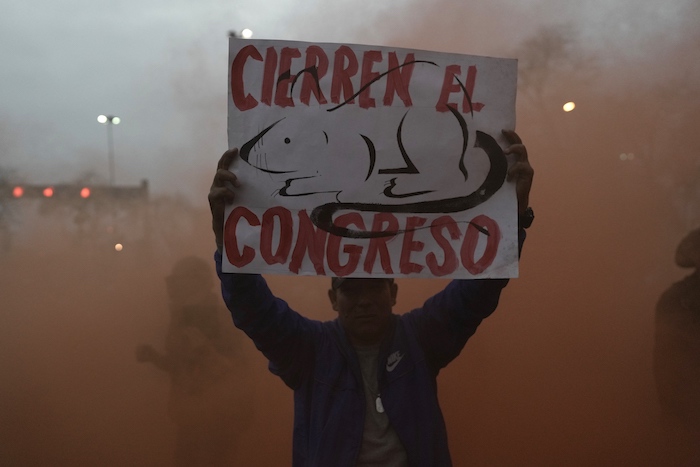 Manifestante de oposición lleva un cartel que pide el cierre del Congreso en una protesta en el centro de Lima, Perú, el miércoles 19 de julio de 2023.