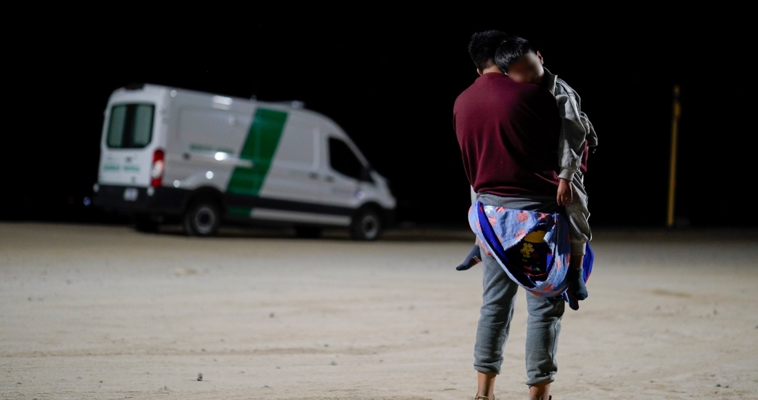 Un hombre colombiano carga a su hijo mientras espera a solicitar asilo después de cruzar la frontera desde México, el martes 11 de julio de 2023, cerca de Yuma, Arizona. Foto: Gregory Bull, AP