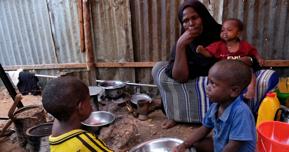 Hadiiq Abdulle Mohamed come con sus hijos mientras habla con The Associated Press en un campamento de personas desplazadas el 24 de marzo de 2023, en las afueras de Mogadiscio, Somalia. Foto: Farah Abdi Warsameh, AP, Archivo