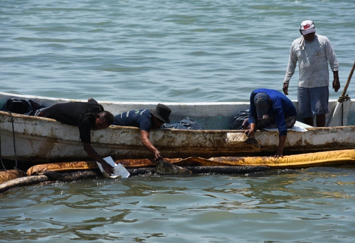 Continúan los trabajos de limpieza y detención de manchas de combustóleo en orillas de la playa de Campeche, a pesar de que trabajadores han contenido partes de crudo que el mar está arrojando, el olor a combustóleo se percibe desde la entrada a la playa. Foto: Michael Balam Chan, Cuartoscuro