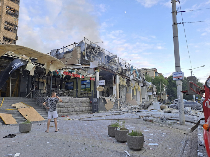 En esta fotografía proporcionada por el Gobierno regional de Donetsk, Ucrania, un hombre está de pie en la calle frente a un restaurante de pizza, en Kramatorsk, Ucrania, el martes 27 de junio de 2023.