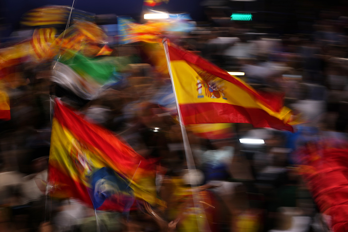 Simpatizantes del Partido Popular ondean banderas de España mientras esperan la comparecencia de su candidato a la Presidencia, Alberto Núñez Feijóo, en el exterior de la sede de la formación conservadora durante la noche electoral, el 23 de julio de 2023, en Madrid.