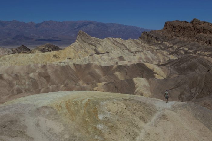 Un hombre camina por un sendero del cañón Golden en el Parque Nacional Valle de la Muerte, California, el martes 11 de julio de 2023.