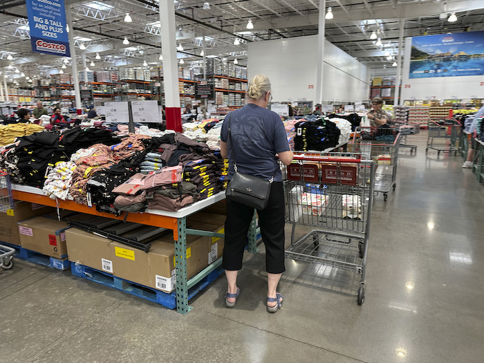 Una compradora junto a pilas de ropa en un almacén de la cadena Costco el jueves 22 de junio de 2023 en Colorado Springs, Colorado.