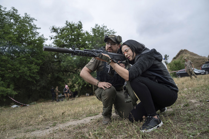 Una mujer dispara un AK-47 durante un entrenamiento táctico para civiles cerca de Zaporiyia, Ucrania, el domingo 9 de julio de 2023.