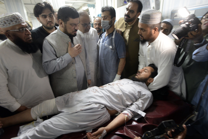 Varias personas transportan a una persona herida por una poderosa bomba a su llegada a un hospital el domingo 30 de julio de 2023, en Peshawar, Pakistán. La bomba estalló durante un mitin político.