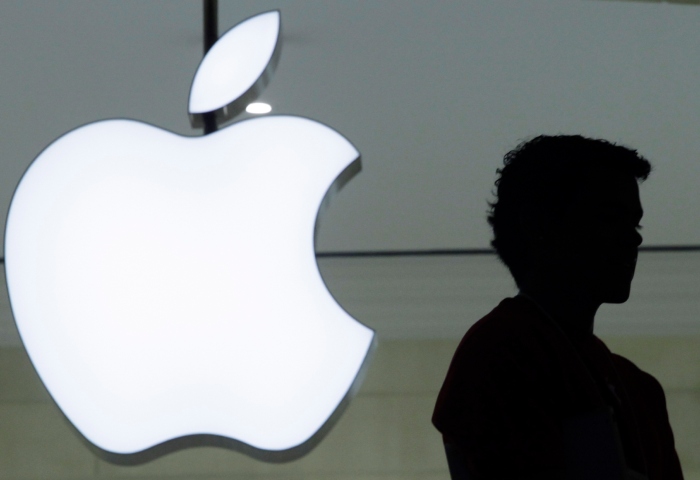 Una persona pasa frente a un logo de Apple en la tienda de la marca en Grand Central Terminal, en Nueva York, el 7 de diciembre de 2011. Foto: