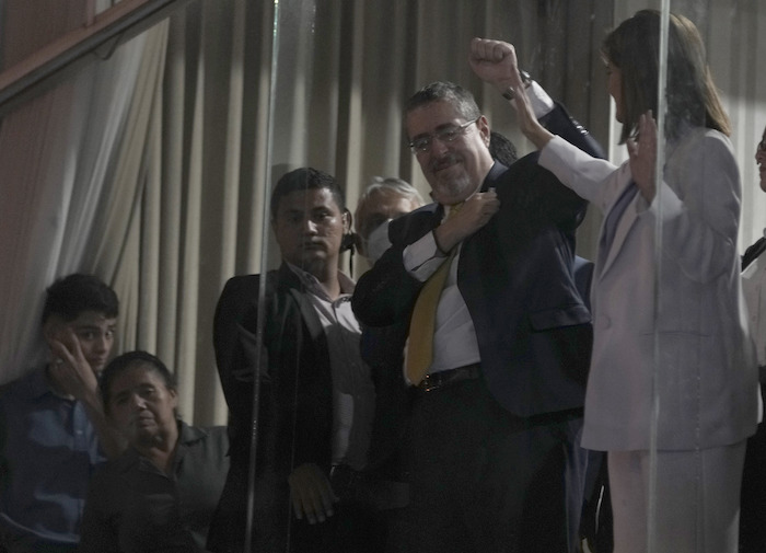 El candidato presidencial Bernardo Arévalo y su compañera de fórmula Karin Herrera saludan a sus partidarios desde una ventana después de que los resultados preliminares los mostraran como los vencedores en una segunda vuelta de las elecciones presidenciales en la Ciudad de Guatemala, el domingo 20 de agosto de 2023.