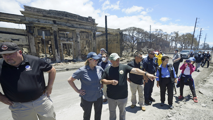 El Gobernador de Hawai, Josh Green, centro, habla con la administradora de la Agencia Federal de Manejo de Emergencias (FEMA) Deanne Criswell en una recorrida de la zona arrasada por los incendios, 12 de agosto de 2023 en Lahaina, Hawai.